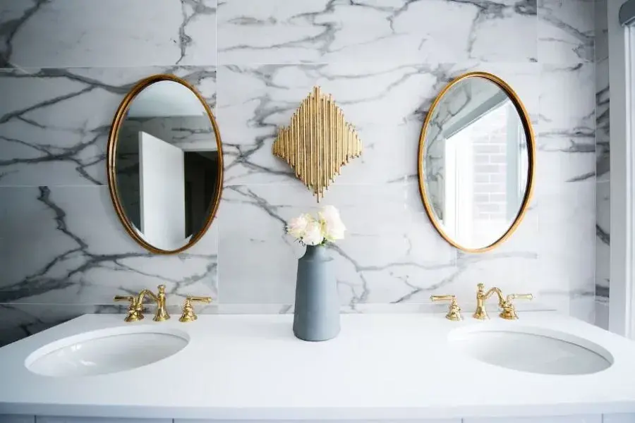 A bathroom with round mirrors and white wash basin